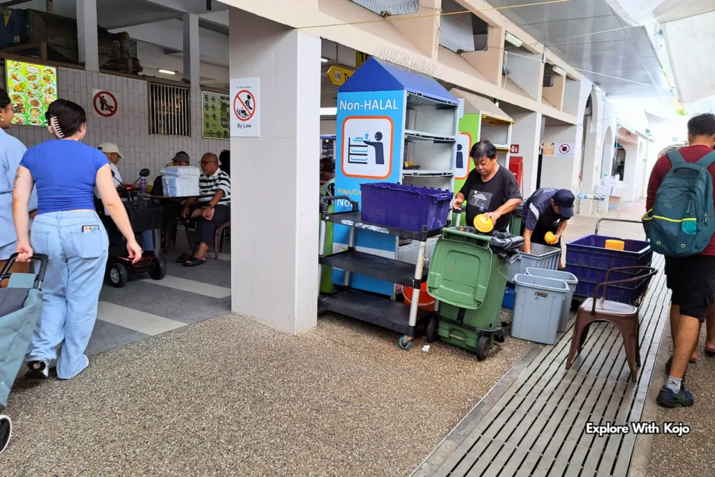 Market workers moving carts and supplies at a Singapore Pasar Malam.