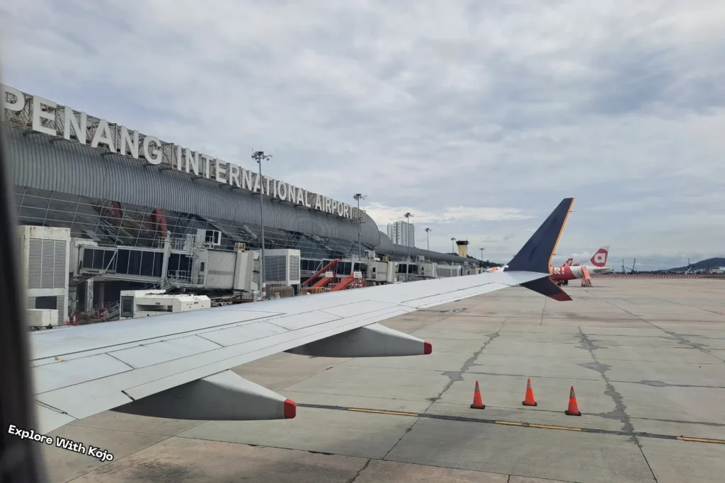 View of Penang International Airport terminal and runway from airplane window