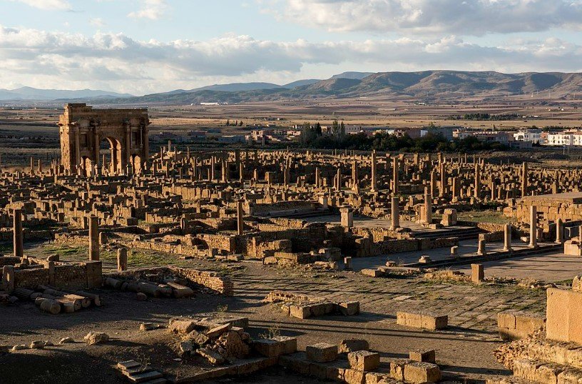 Ancient Roman arch and ruins at Timgad archaeological site in Algeria. 
