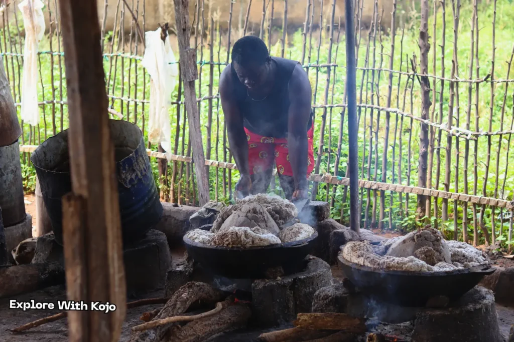 Worker scooping African black soap from a pot over fire in Ghana