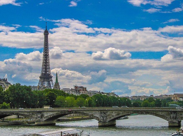 Boat cruising along the Seine River in Paris with city landmarks.