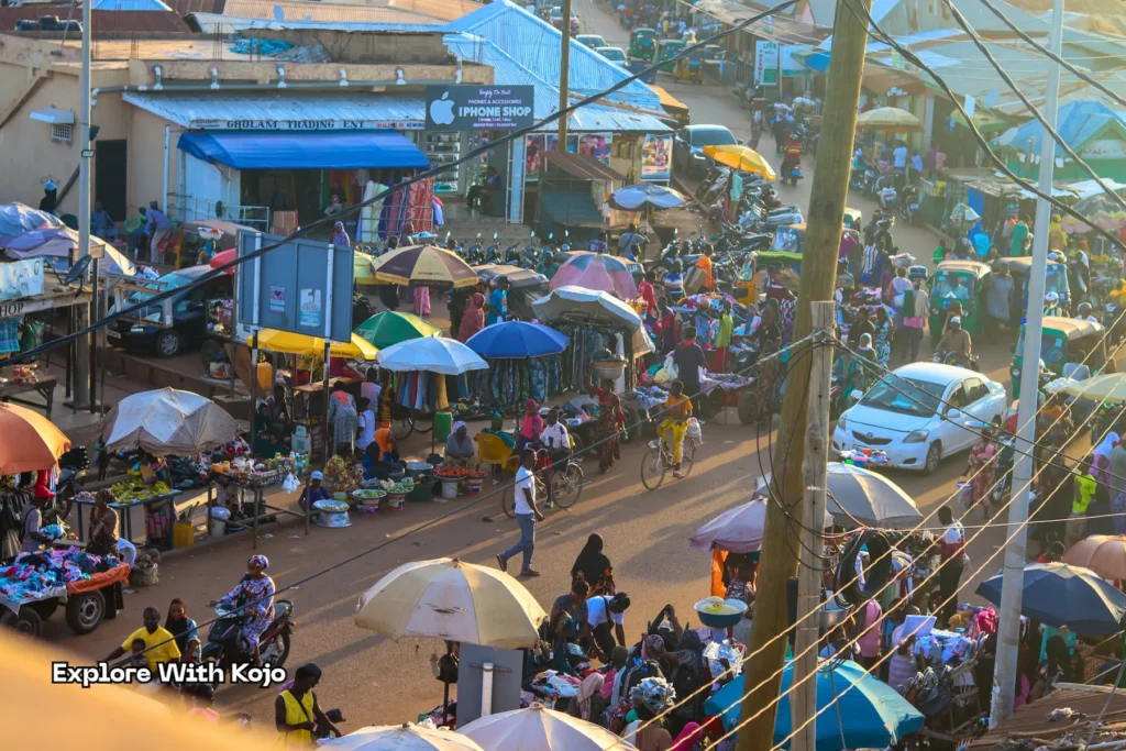 Crowded Tamale market street with stalls and tricycles