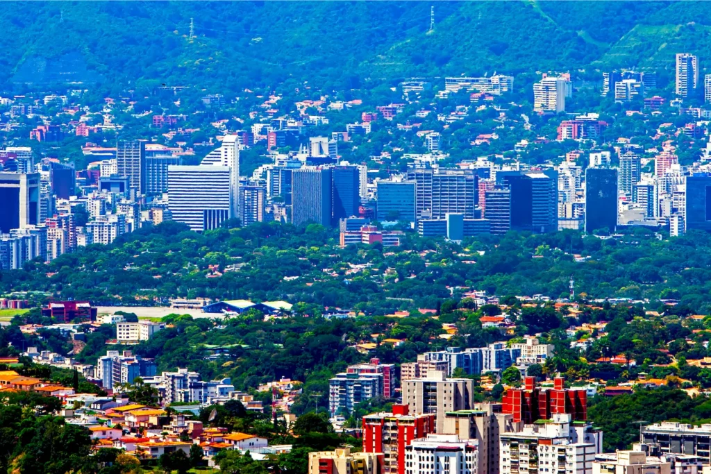 Aerial view of Caracas, Venezuela, surrounded by green hills.