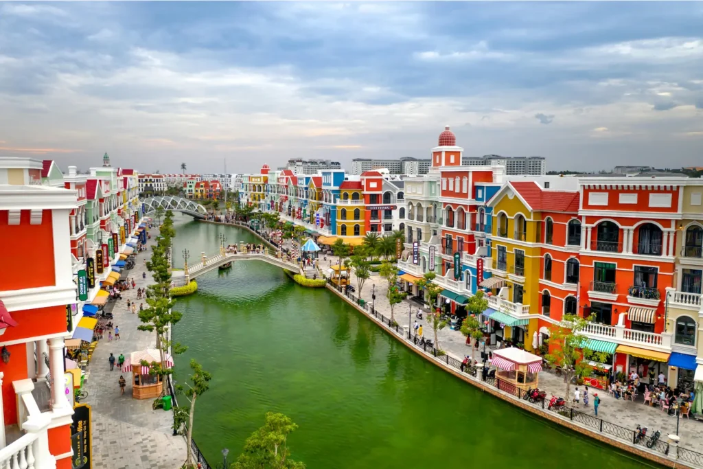 Colorful buildings along a riverfront in Vietnam under a bright sky.