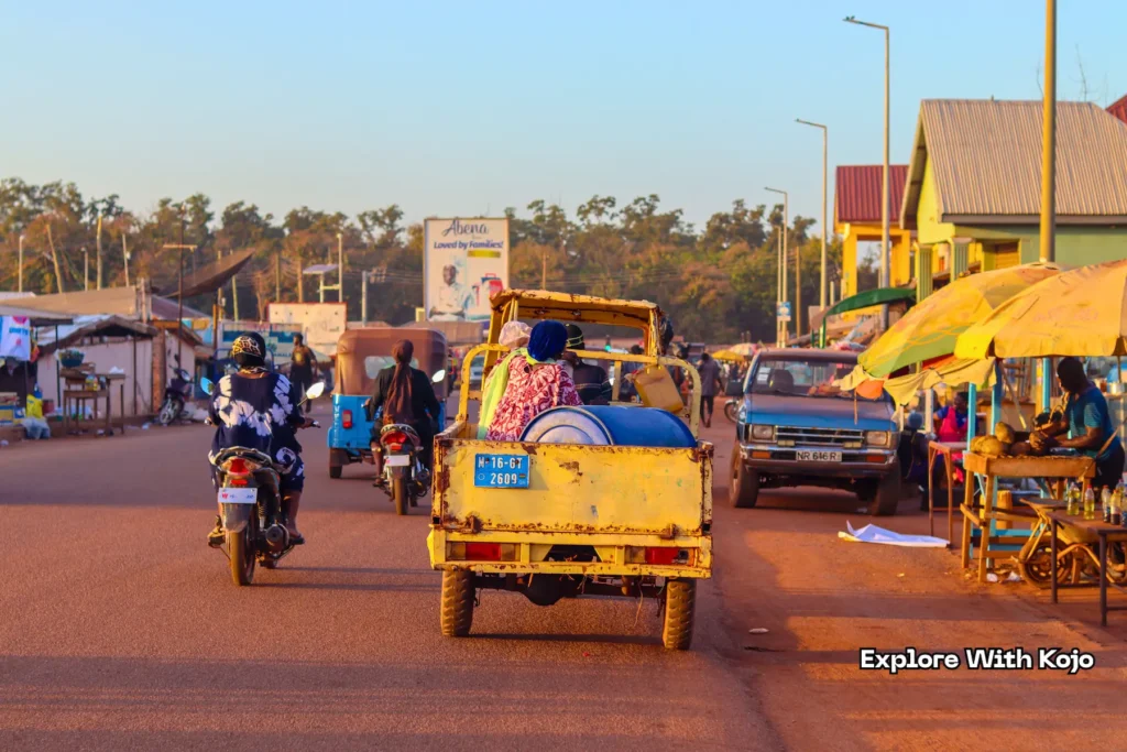 Woman sitting in Motorking tricycle with her goods in Tamale