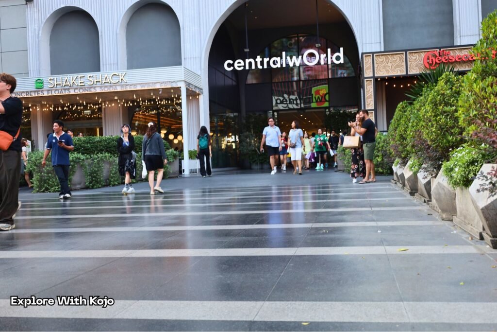 Entrance of CentralWorld in Bangkok with shoppers walking across the plaza.