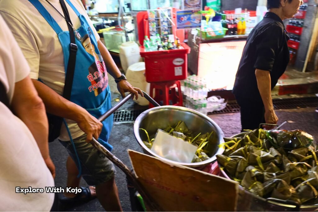Dumplings being pushed in a cart for sale along Yaowarat Road in Bangkok Chinatown.