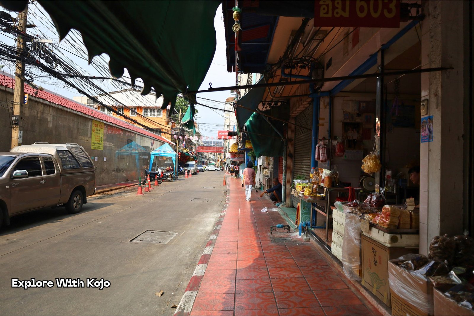 Local street in Bangkok showing shops, pedestrians, and market stalls on the way to nearby beaches like Bang Saen.