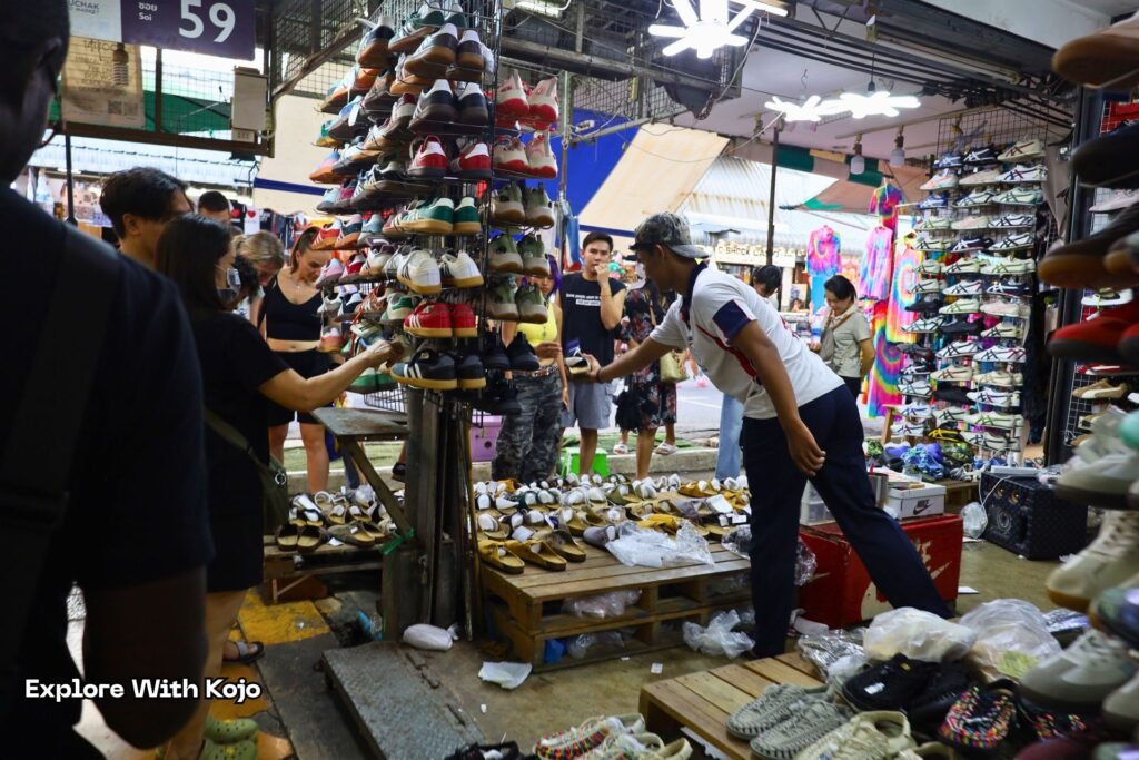 Tourists browsing a busy Bangkok market where many prices are negotiable, reminding visitors that not everything in Thailand is fixed price.