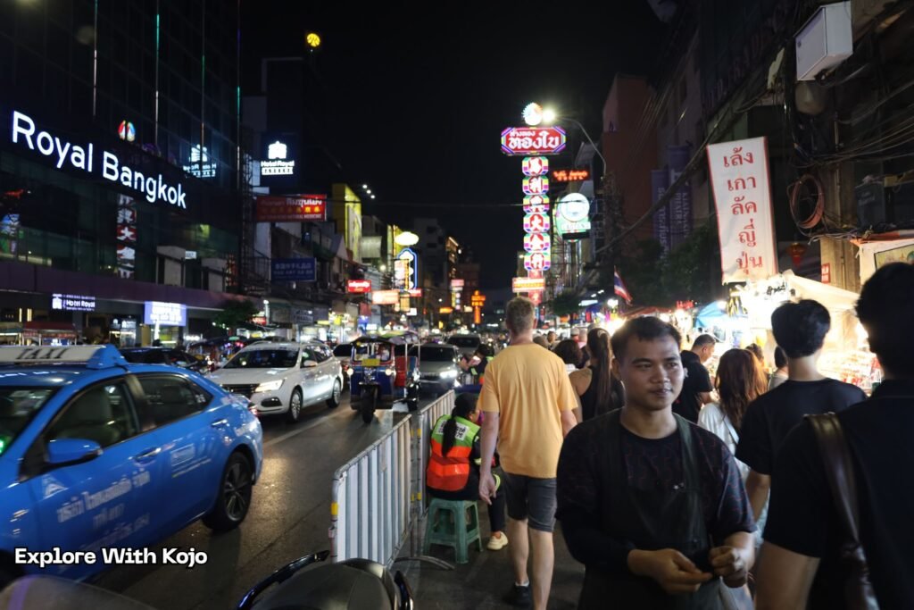 Busy night scene in Bangkok with crowded streets, neon signs, and taxis, showing the lively and safe atmosphere for visitors.