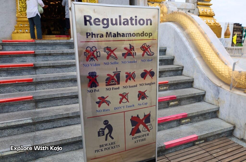 Sign showing the strict rules at the entrance of a Bangkok temple, reminding visitors about dress code, no selfies, no shoes, and general temple etiquette.