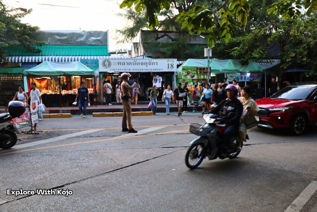 Entrance area of Chatuchak Weekend Market showing crowds and vendors.