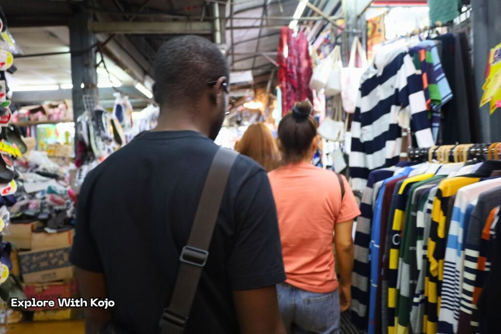 Kojo walking through the crowded alleys of Chatuchak Weekend Market.