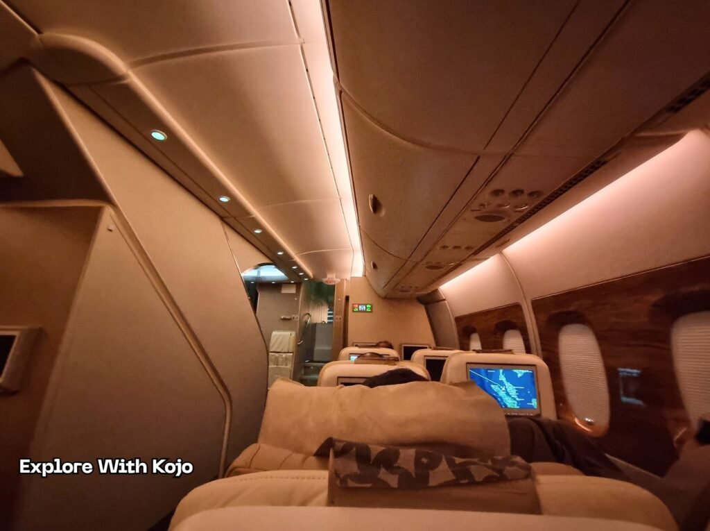 Emirates Premium Economy cabin at night with warm lighting and spacious seats.