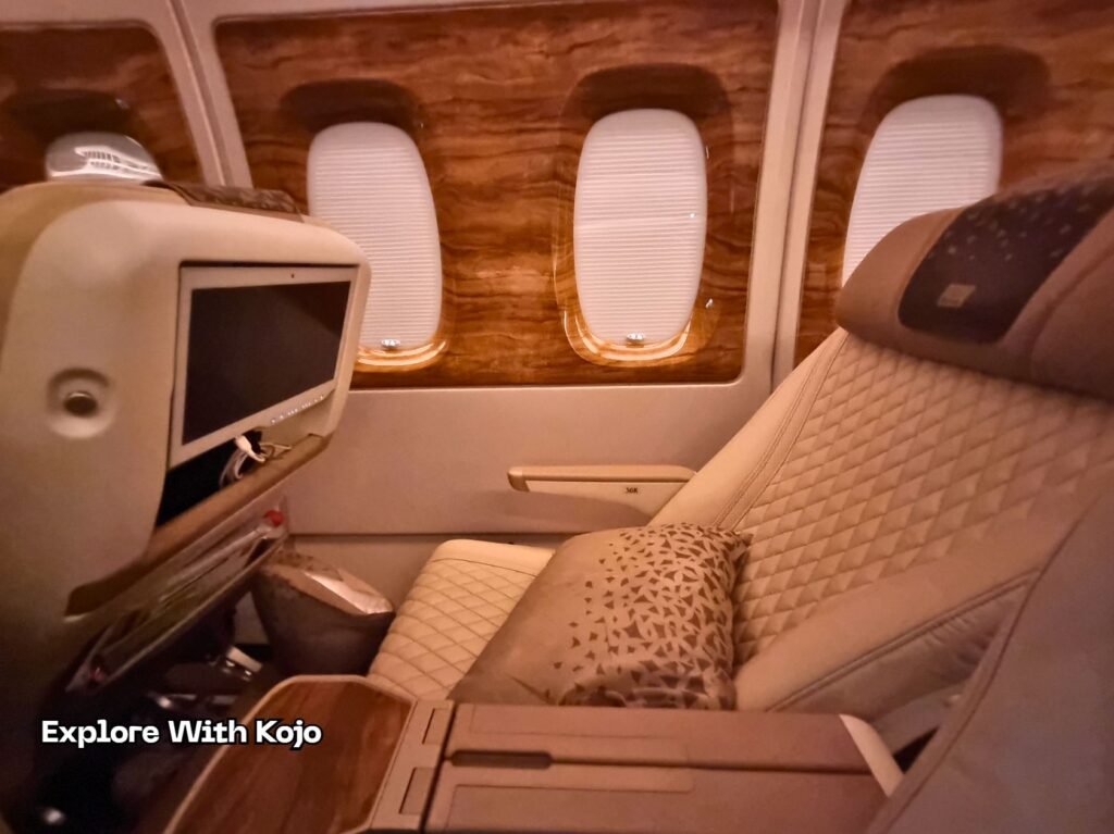 Emirates Premium Economy seat with quilted leather design, pillow, and wide entertainment screen.