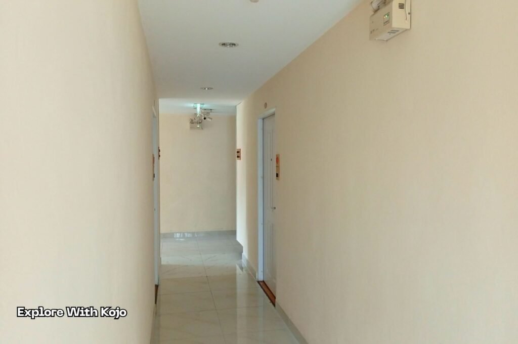 A hotel hallway showing several room doors, used to explain why travelers should request a room on a different floor if they suspect recent pest treatment.