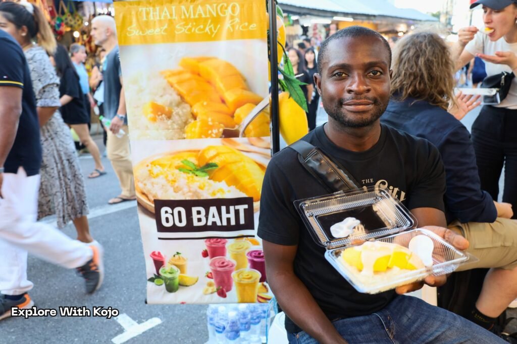 Kojo enjoying mango sticky rice at Chatuchak Weekend Market.