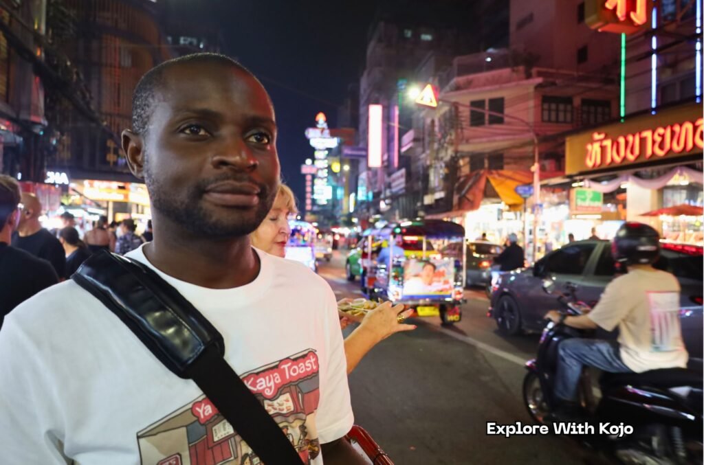 Kojo Enoch exploring the vibrant Yaowaraj Street Food area in Chinatown Bangkok at night.