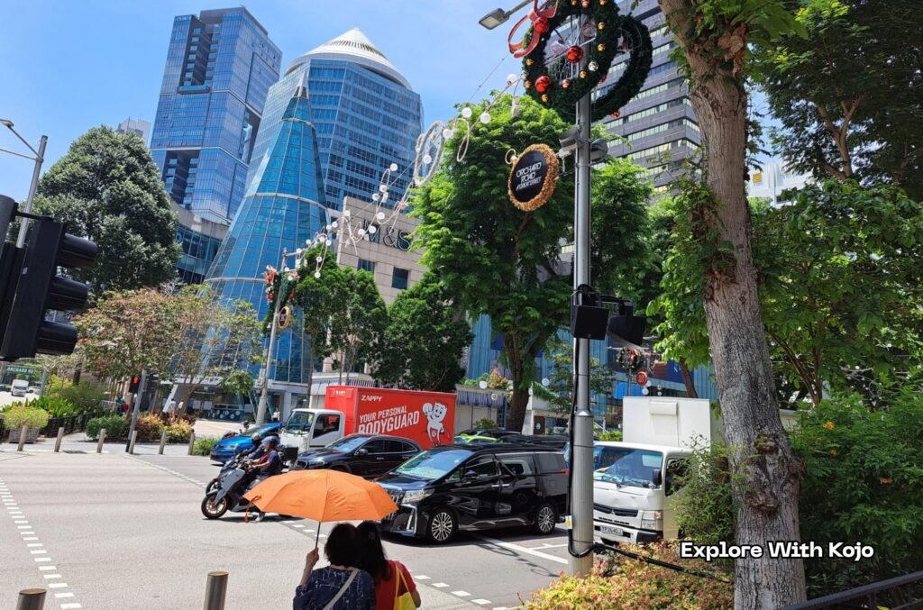 Daytime view of Orchard Road with Christmas wreaths and ornaments hanging over the street.