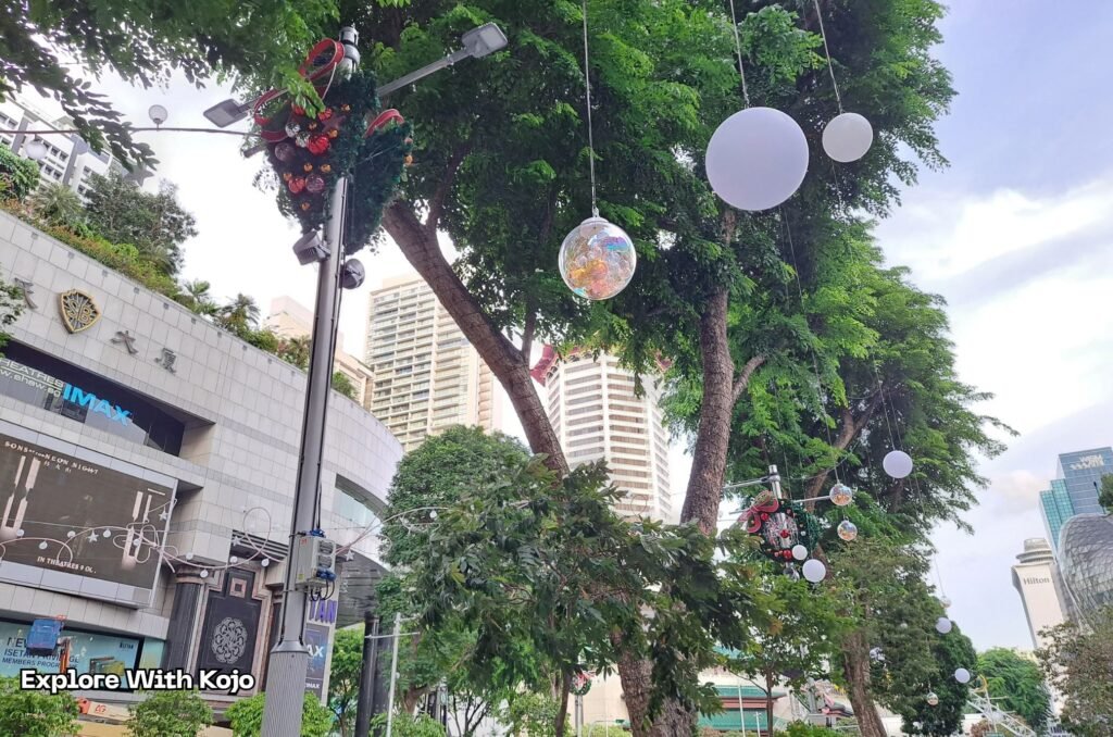 Hanging Christmas ornaments and glowing bulbs along Orchard Road.
