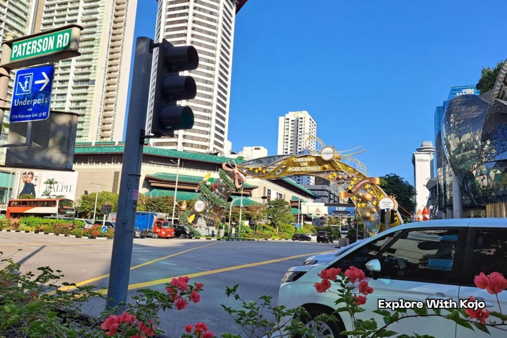 Orchard Road Christmas arch near Paterson Road under a bright blue sky.
