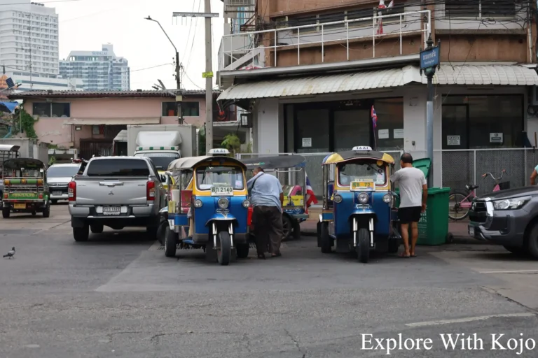 Tuk-tuks parked along a quiet Bangkok side street.