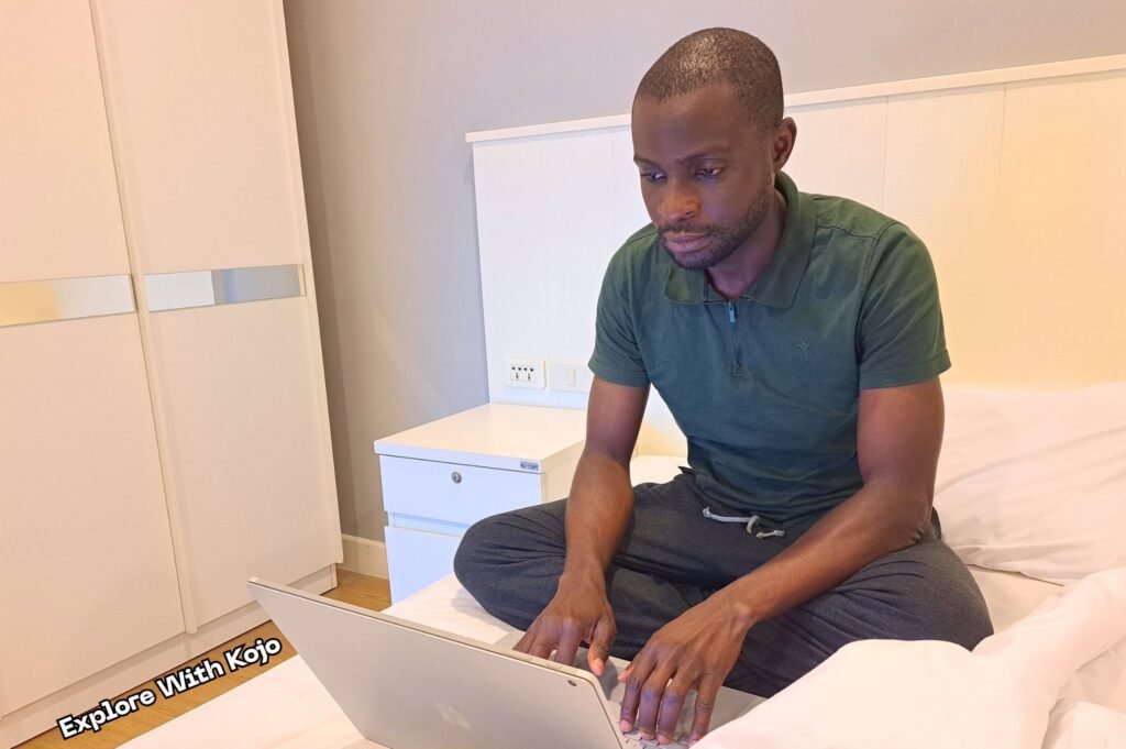 Man working on a laptop from his bed, an example of a bad remote work habit.