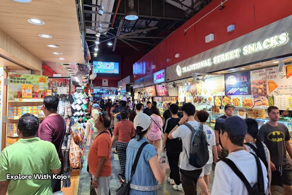 Crowded evening scene at Bugis Street Singapore with shoppers moving through the market.