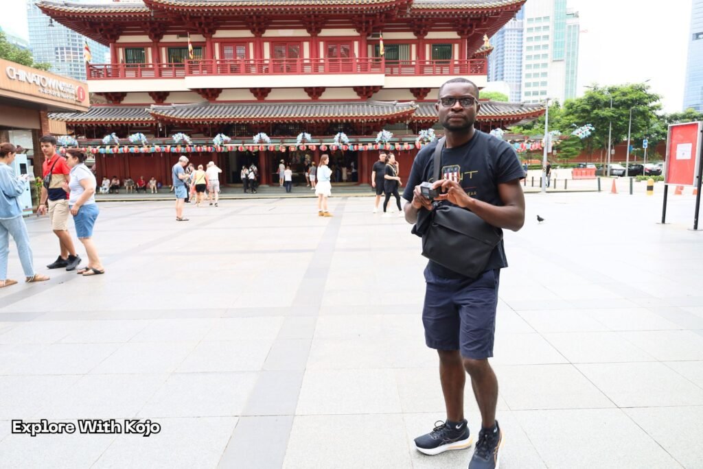Kojo from Explore With Kojo standing in front of the Buddha Tooth Relic Temple in Singapore’s Chinatown