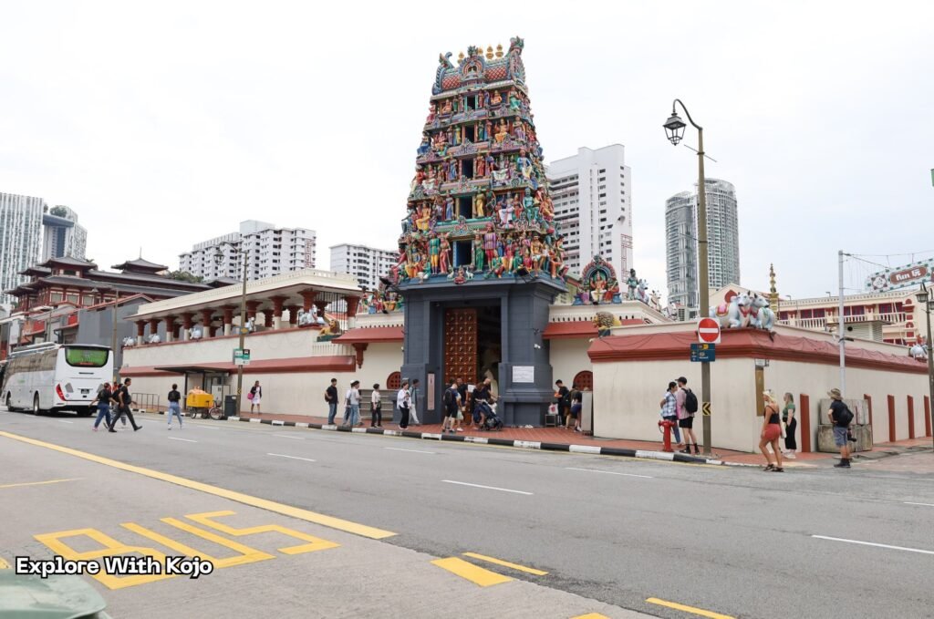 Sri Mariamman Temple in Singapore’s Chinatown with visitors walking outside the historic Hindu temple