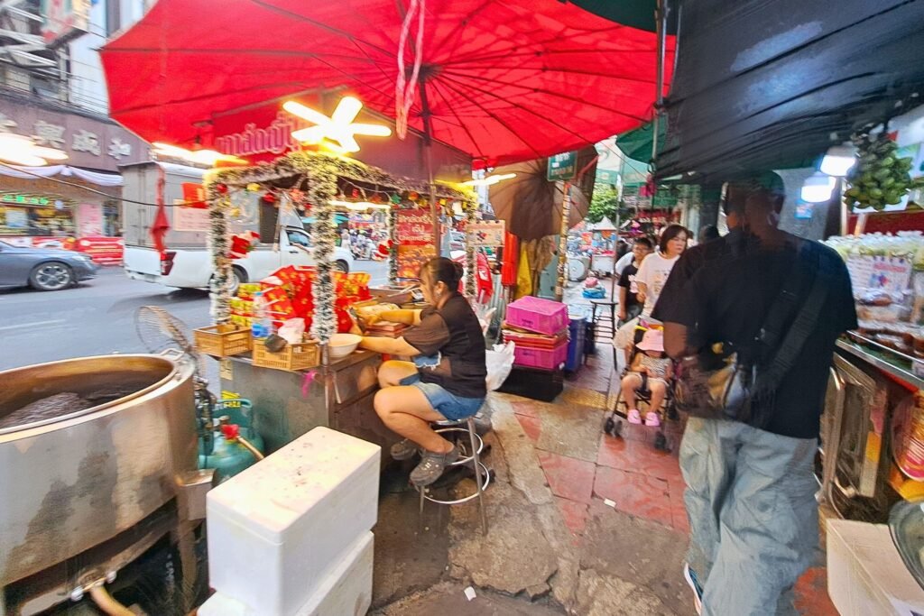 Thai woman mending her food booth at a night market in Bangkok